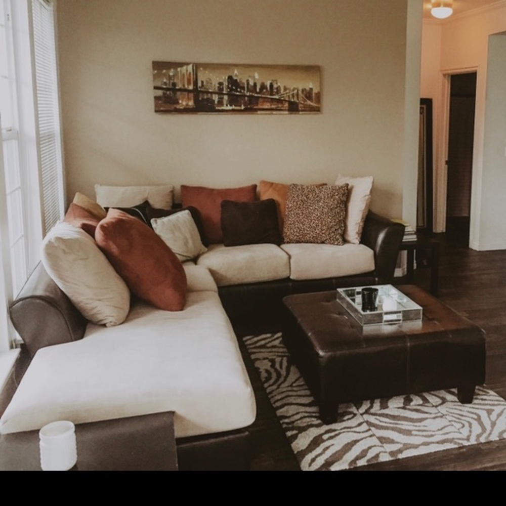 Brown leather and suede beige couch and ottoman.